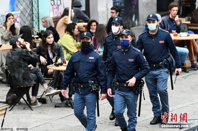 资料图：警察在米兰Navigli运河旁的步行街巡逻。