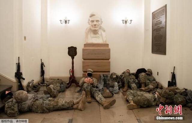 当地时间1月13日，美国国会大厦的圆形大厅，国民警卫队队员正在休息。