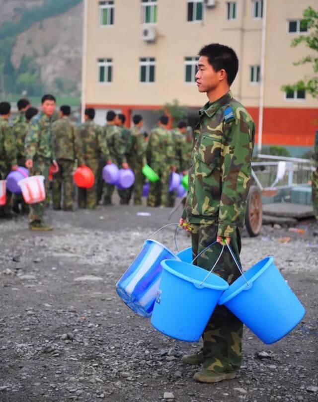 图为抗震救灾期间，官兵排队打水。