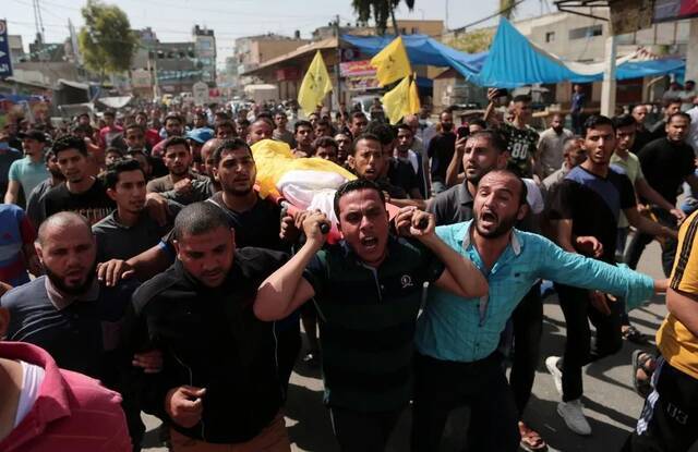 当地时间2021年5月11日，在加沙地带拜特哈嫩，人们运送空袭遇难者的遗体。