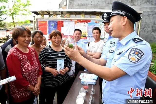 民警到乡村宣传禁毒知识，教民众识别罂粟。王东明摄