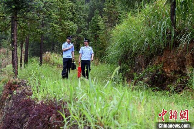 车到不了的地方，民警跋山涉水步行前往。王东明摄