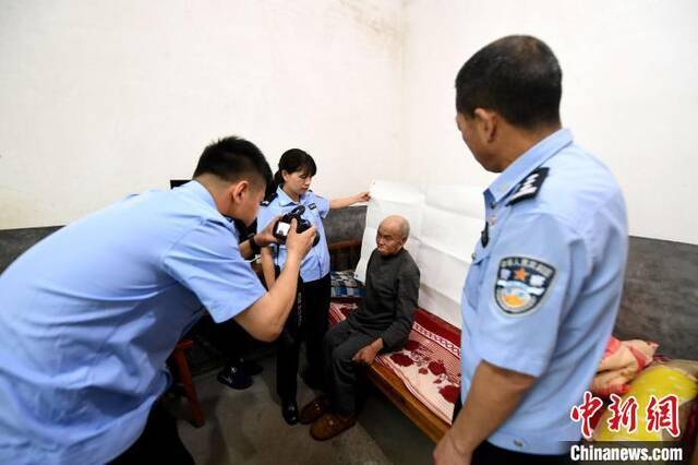 图为挂村民警上门为93岁老人办理二代身份证。王东明摄