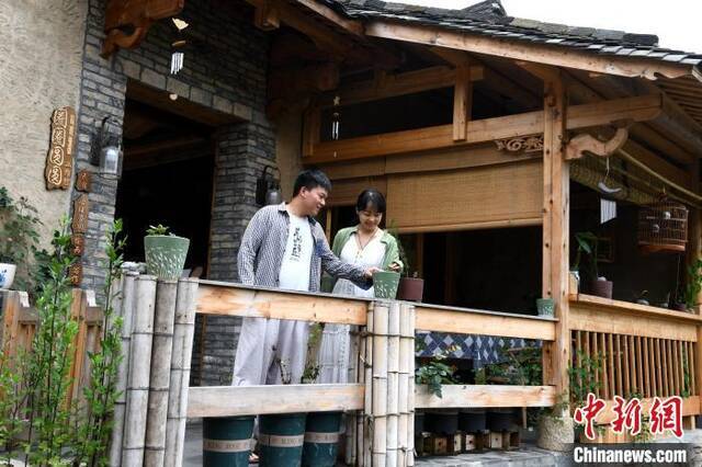 来自浙江的“新村民”温先生和蔡小姐在自己修缮的古厝前休闲。王东明摄
