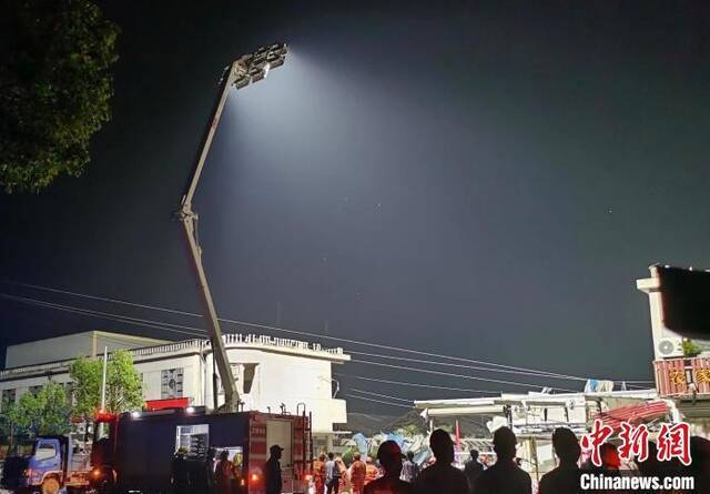 由于电力设施损坏，周边停电。消防车用探照灯为救援照明。钟升摄