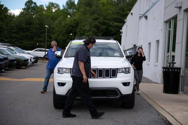 ▲美国宾夕法尼亚州，一名顾客正在对吉普的新车进行检查。图据《华尔街日报》
