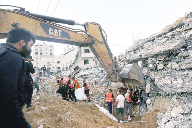 图为救援人员在加沙地带城镇拜特拉希亚遭以军空袭的废墟中搜救。新华社发（里泽克·阿卜杜勒·贾瓦德摄）