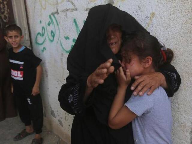 ↑5月17日，在加沙地带拉法举行的一场葬礼上，在以军空袭中丧生的巴勒斯坦人的亲属悲痛不已。图据新华社