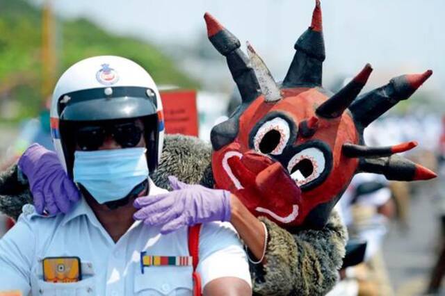 4月29日，在印度金奈，警察装扮成冠状病毒形象上街宣传防疫知识。图/人民视觉