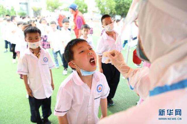 5月22日，学生在六安市城北小学接受核酸采样。新华社记者张端摄