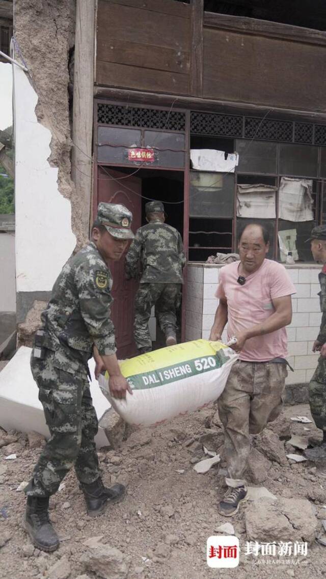 武警官兵帮助灾民搬粮食