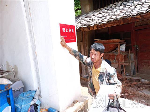 村民陈明金亲手给自家的房子贴上禁止使用的标签时，心里难受。
