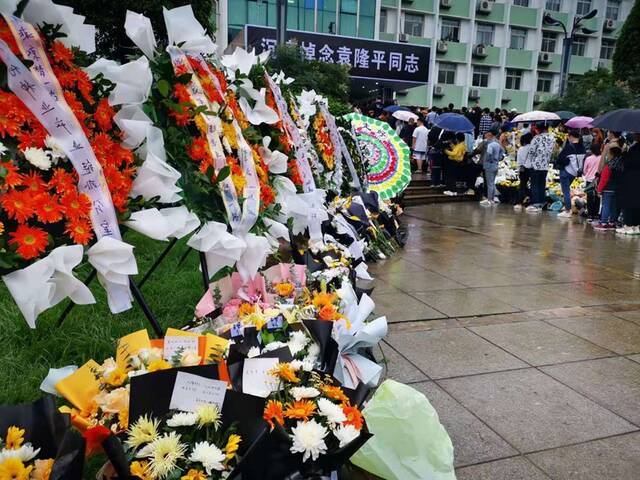 杂交水稻研究中心办公楼下的献花和悼念群众。澎湃新闻记者谭君图