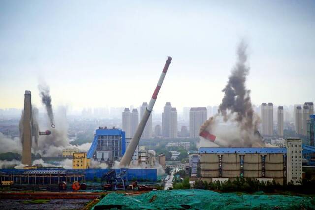 2017年6月23日，天津陈塘热电厂的3座烟囱和1座水塔实施爆破拆除。该热电厂1995年正式运行，2015年3月关停。摄影/本刊记者佟郁