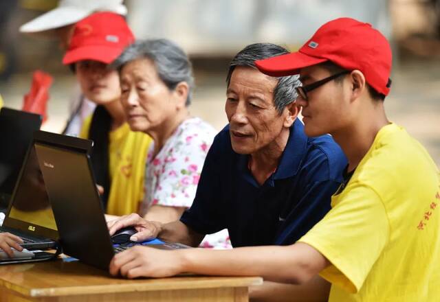 大学生党员志愿者教老年人用电脑上网。新华社记者王晓摄