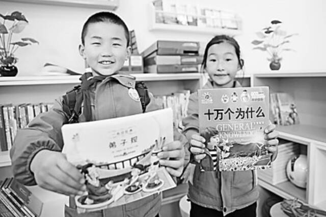 近年来，赠书助学进校园活动丰富了孩子的文化生活。图为甘肃兰州某小学学生展示获赠图书。新华社发