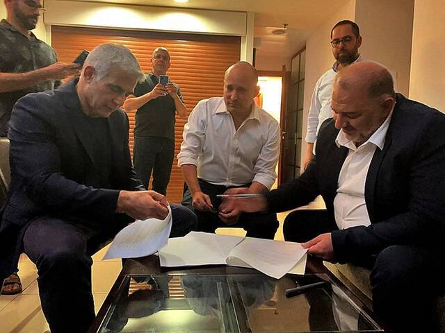 2021年6月2日，阿拉伯以色列伊斯兰保守派政党领导人阿巴斯（右）与拉皮德（左）和贝内特签署联合协议。图片来源：视觉中国