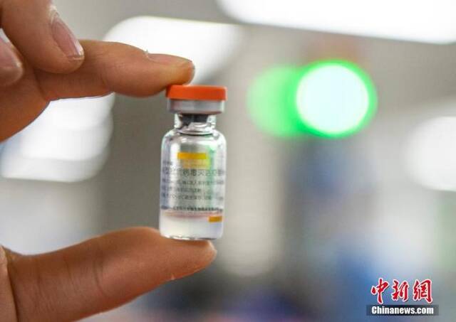 图为2021年1月6日，位于北京市大兴区的北京科兴中维生物技术有限公司的仓库内，工作人员展示一支西林瓶装新冠灭活疫苗。（资料图片）中新社记者侯宇摄