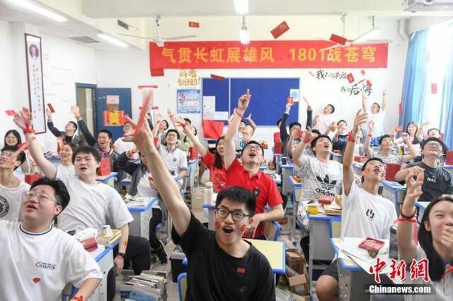 资料图：6月6日，湖南长沙同升湖实验学校教师与考生抛起红包迎接高考。杨华峰摄