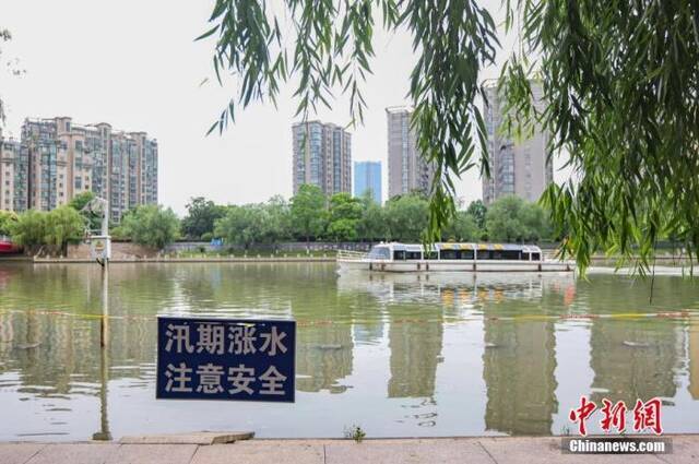 资料图：6月3日，江苏省南京市，秦淮河石头城段挂着“汛期涨水注意安全”警示牌。中新社记者泱波摄