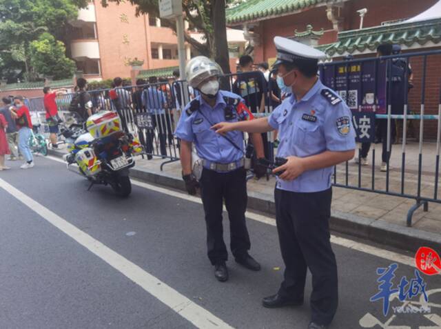 交警们手戴“护卫高考”的红袖章维持交通秩序
