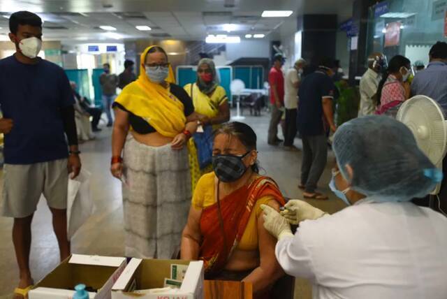 ▲印度民众接种疫苗。图源/新京报网。