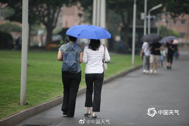 北京雷声隆隆雨水洒落 街头行人步履匆匆