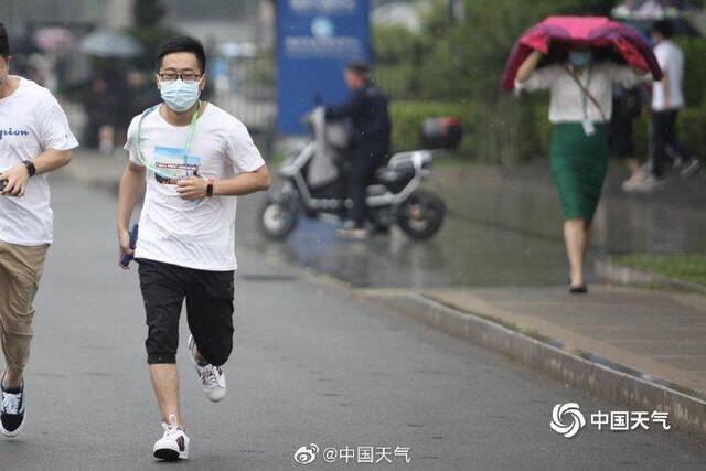 北京雷声隆隆雨水洒落 街头行人步履匆匆