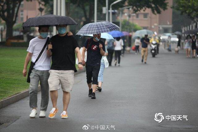 北京雷声隆隆雨水洒落 街头行人步履匆匆