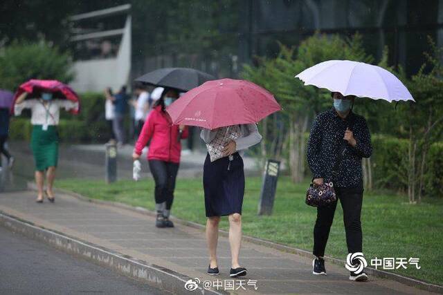 北京雷声隆隆雨水洒落 街头行人步履匆匆