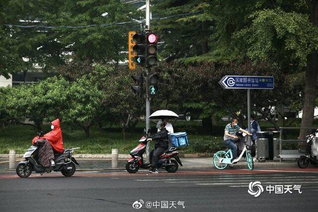 北京雷声隆隆雨水洒落 街头行人步履匆匆