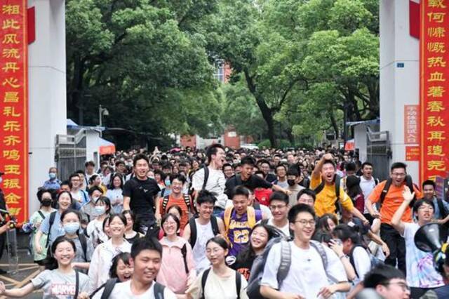 △6月9日，湖南长沙市一中考点前，考生高高跃起庆祝考试结束。（图片来源：视觉中国）