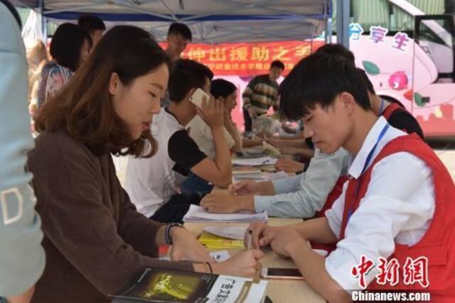 资料图：大学生在爱心献血点咨询献血活动。邓天运摄