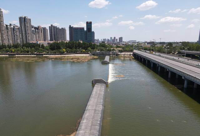 5月29日，水流过白庙橡胶坝，右侧为潮白河大桥。新京报记者王贵彬摄