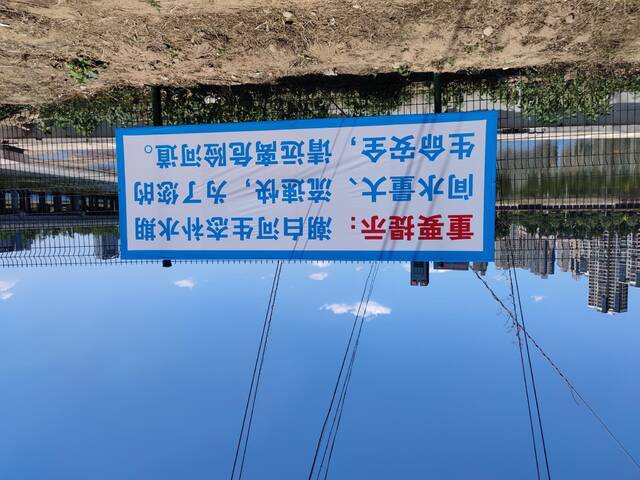潮白河白庙橡胶坝附近的补水安全提示标语。新京报记者赵敏摄