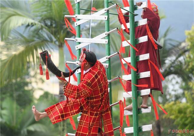 在罗城仫佬族自治县民族文化广场，民间艺人正在进行传统体育杂技“上刀山”表演。（蒙增师/摄）