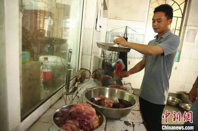 饲养员正在准备东北虎“文文”要吃的碎肉。朱柳融摄
