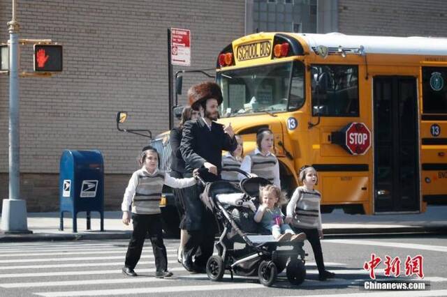 资料图：当地时间5月17日，民众从美国纽约市犹太社区的一所学校外经过。中新社记者廖攀摄