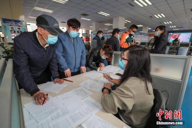 资料图：4月2日，北京市顺义区人力资源市场内，求职者（左）与用工企业交谈。中新社记者贾天勇摄