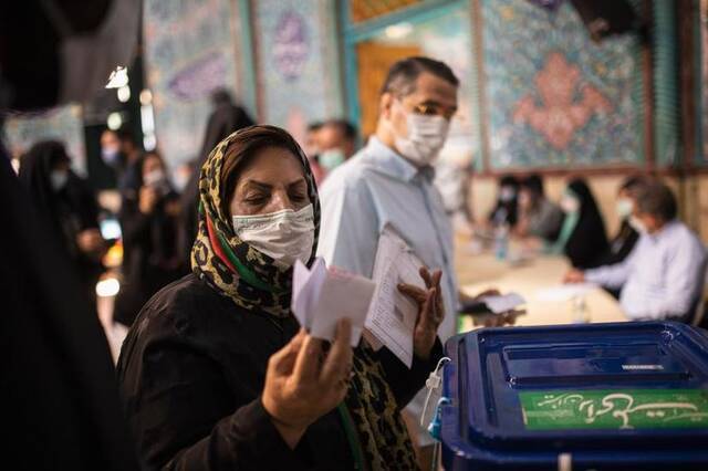 6月18日，人们在伊朗德黑兰一个投票点投票。新华社发（艾哈迈德·哈拉比萨斯摄）