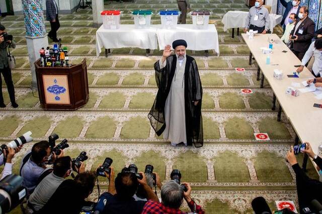 6月18日，易卜拉欣·莱希在德黑兰的一个投票站投票后向媒体致意。新华社发（艾哈迈德·哈拉比萨斯摄）