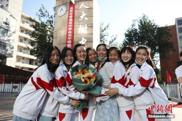 资料图：6月10日，在北京人大附中高考考点外，考生们相拥拍照留念。当日，北京市2021年高考结束。中新社记者赵隽摄