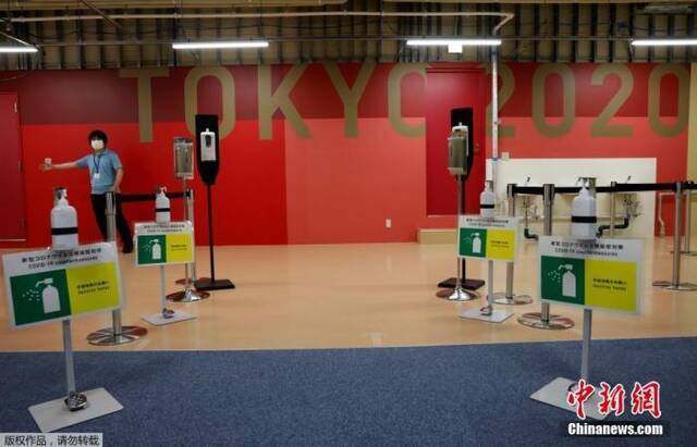 当地时间6月20日，距东京奥运会开幕还有33天时，奥运村首次对媒体开放。图为健身中心入口处摆放有洗手液和防疫标识。