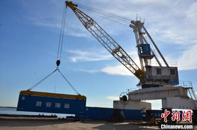吊车向运输船队吊装集装箱。黑龙江省交通运输厅供图
