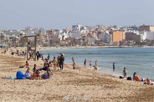 图为3月29日，人们在西班牙马略卡帕尔马的海滩上休闲。