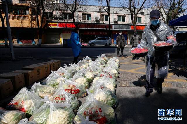 下沉至武汉市花桥社区的干部在搬运居民订购的草莓（2020年2月20日摄）。新华社记者沈伯韩摄