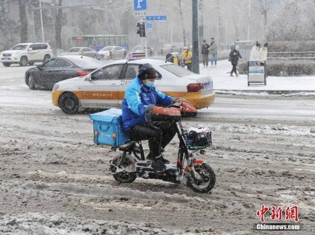 资料图：外卖小哥冒雪送餐。中新社记者刘栋摄