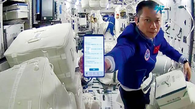 航天员汤洪波展示扫描包裹的信息。
