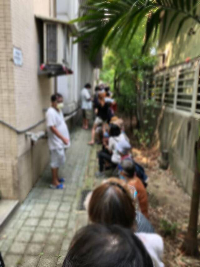 老人挤在小巷等候接种疫苗。