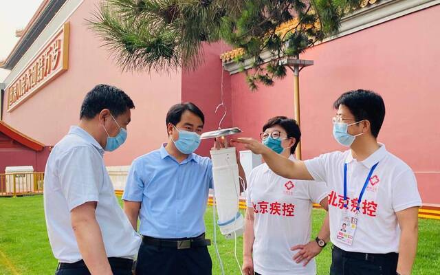 今年6月，张勇（右一）与同事一同检查天安门附近的诱蚊灯。受访者供图